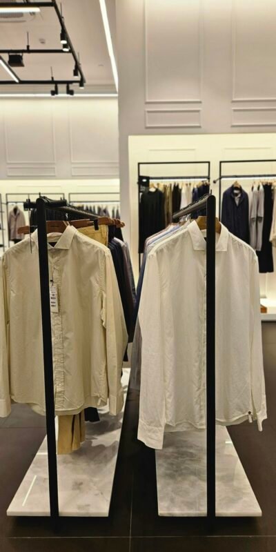 A modern retail store showcasing elegant mens shirts and clothing on display racks.