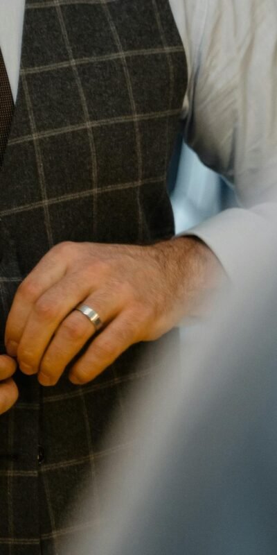 Close-up of a man adjusting his elegant suit jacket with stylish accessories.