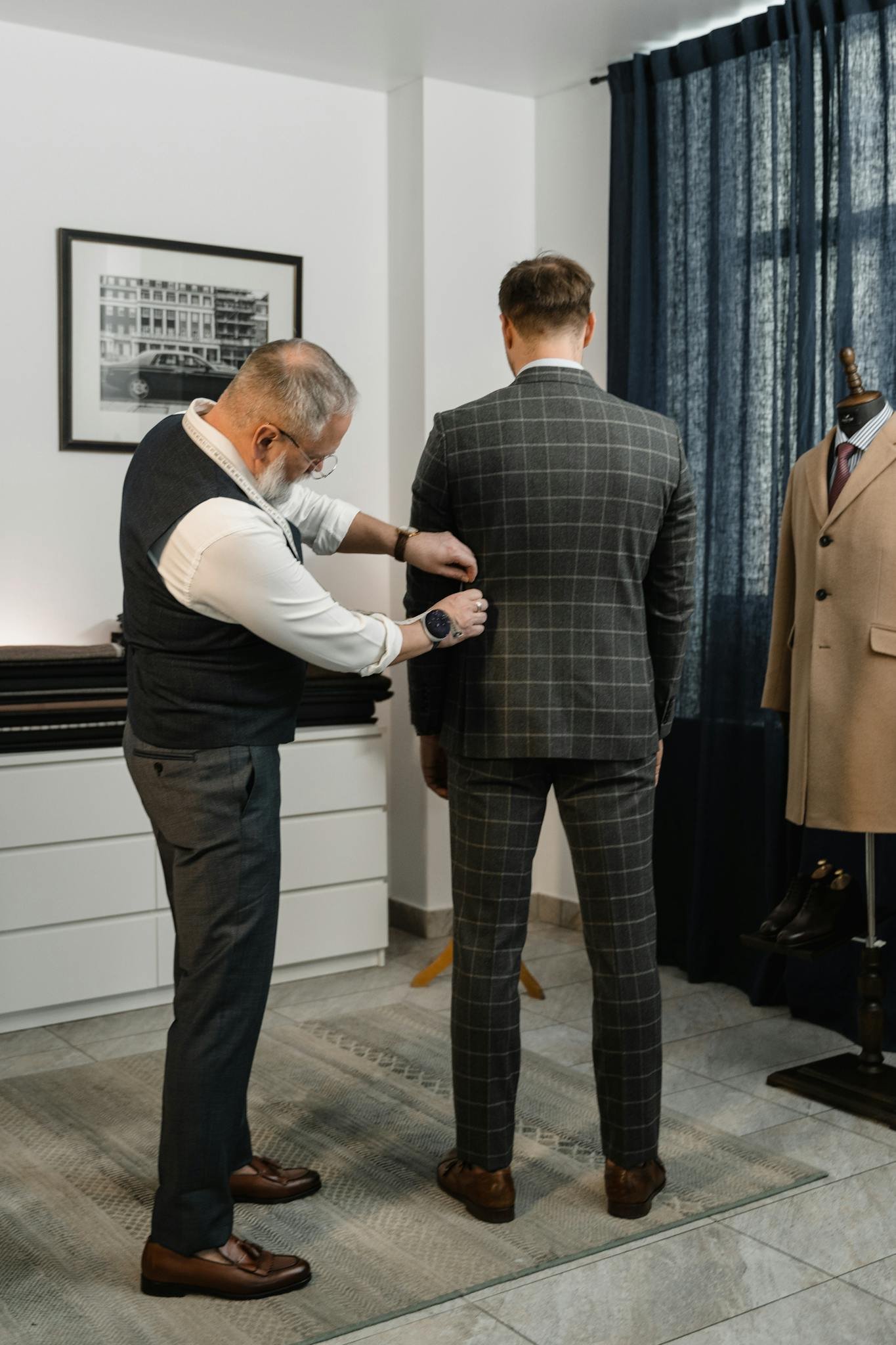 Tailor making precise adjustments on a client's suit inside a fashion atelier.